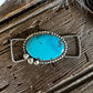 Turquoise stone pendant on a wooden surface