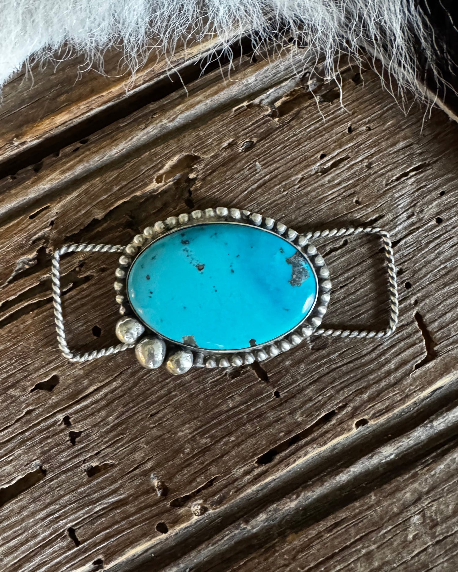 Turquoise stone pendant on a wooden surface