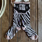 Zebra-patterned sock on a wooden surface with cowhide rug in the background