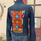 Denim jacket with a colorful pattern on the back, displayed on a mannequin.