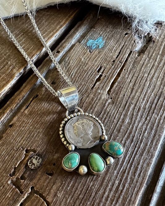 Dime necklace with turquoise stones on rustic wooden background