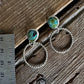 Silver hoop earrings with turquoise stones on a wooden surface next to a ruler.