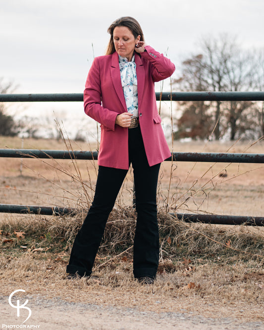 model standing in front of a pipe fence wearing a fashionable western outfit with blazer 