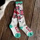 Pair of patterned socks on a wooden floor with cowhide rug