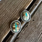 Pair of silver earrings with turquoise stones on a wooden surface
