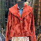 Red jacket on a mannequin with a patterned skirt in a store setting