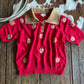 Red outfit with floral patterns on a wooden surface