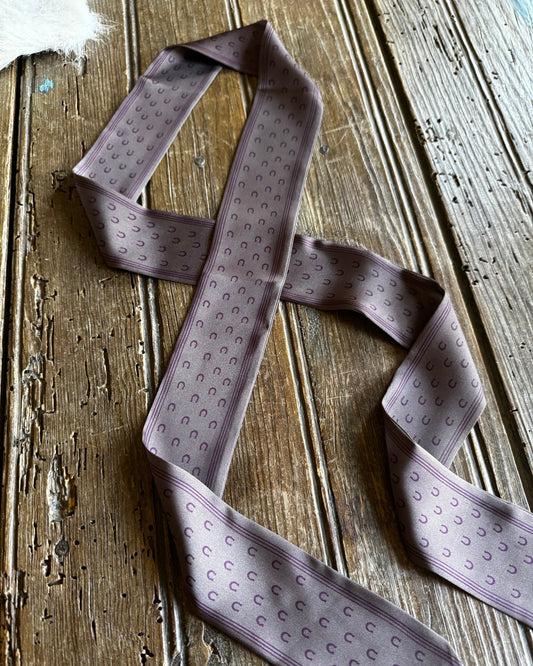 Purple patterned tie on a wooden surface