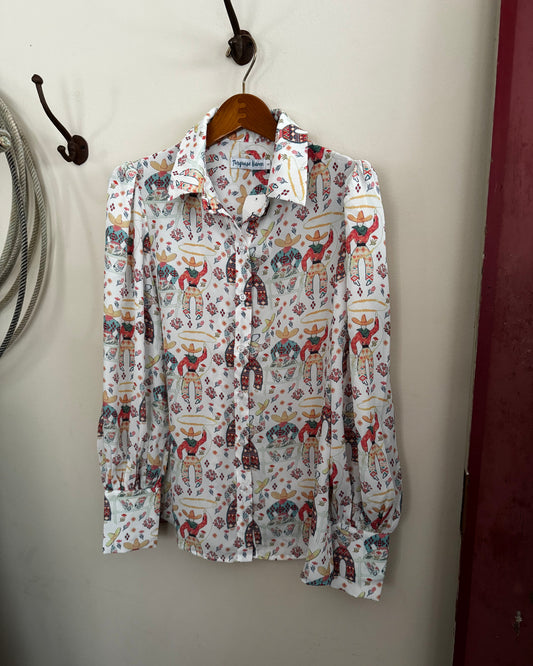 womens printed blouse hanging on a white wall with a rope and a red door