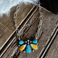 Necklace with a colorful stone pendant on a wooden surface
