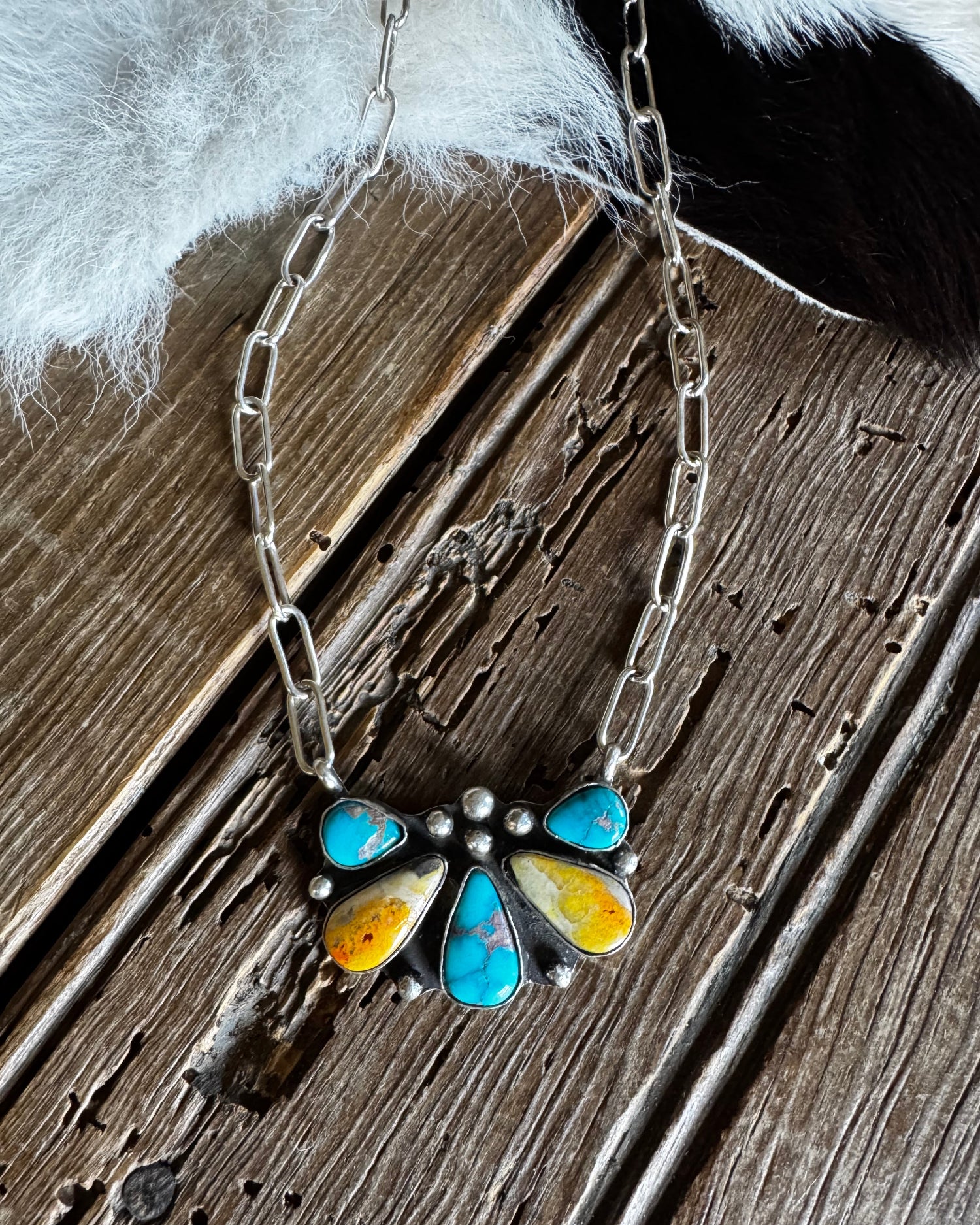 Necklace with a colorful stone pendant on a wooden surface