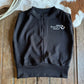 Black pullover with a logo on a wooden surface
