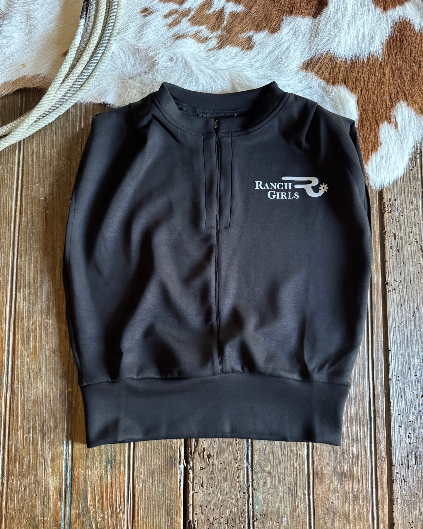 Black pullover with a logo on a wooden surface