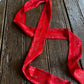 Red bandana with white patterns on a wooden surface