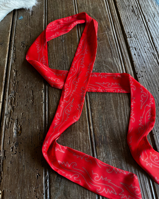 Red bandana with white patterns on a wooden surface