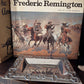 Book titled 'Frederic Remington' with a silver tray in front on a wooden surface