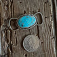 Turquoise stone twilly slide next to a quarter on wooden surface