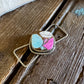 Twilly slide with a multicolored stone pendant on a wooden surface