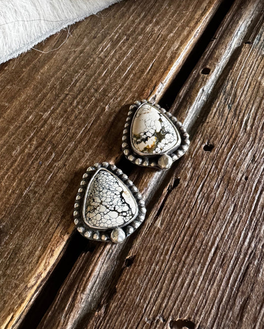 Pair of silver earrings on a wooden surface