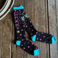 Black socks with pink stars and blue accents on a wooden surface
