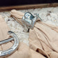 Silver umbrella handles on a beige fabric surface with a blurred background