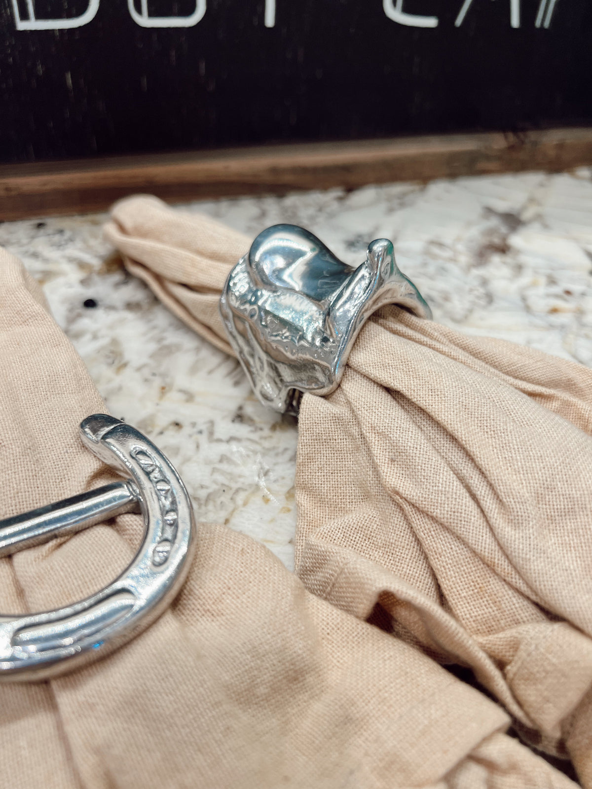 Silver umbrella handles on a beige fabric surface with a blurred background