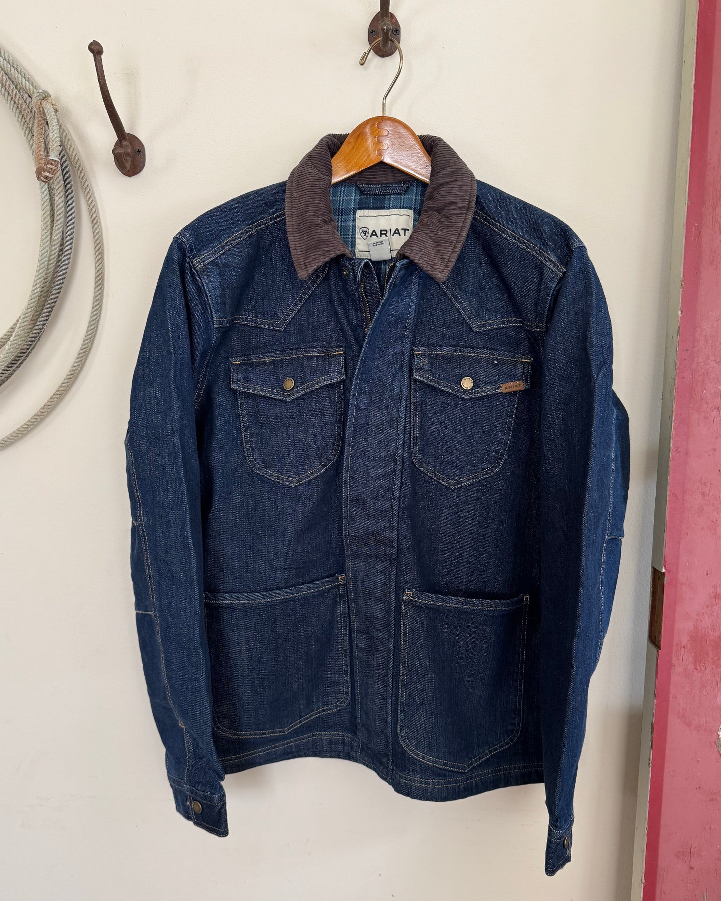 Men's jacket hanging on a white background with a rope 