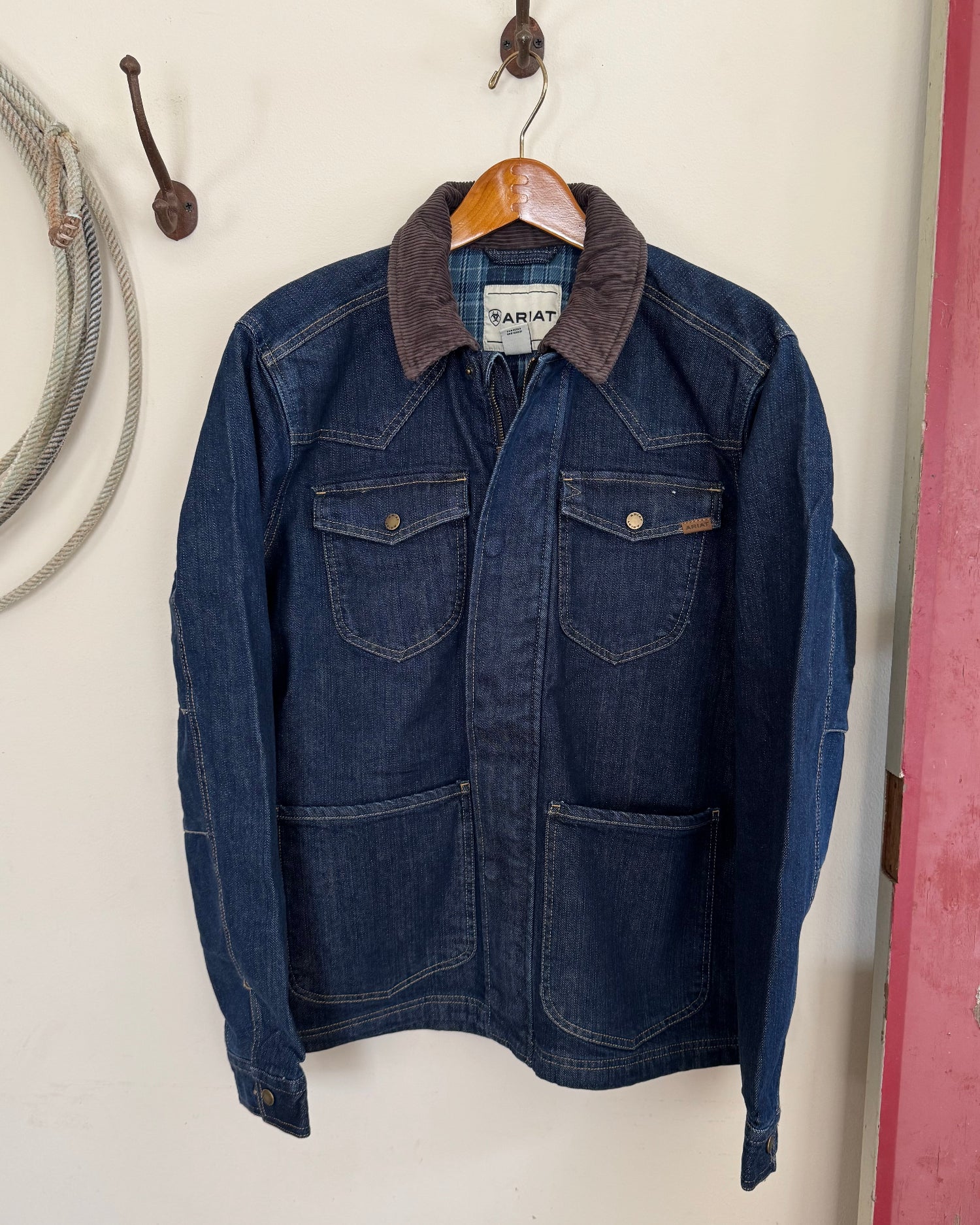 Men's jacket hanging on a white background with a rope 