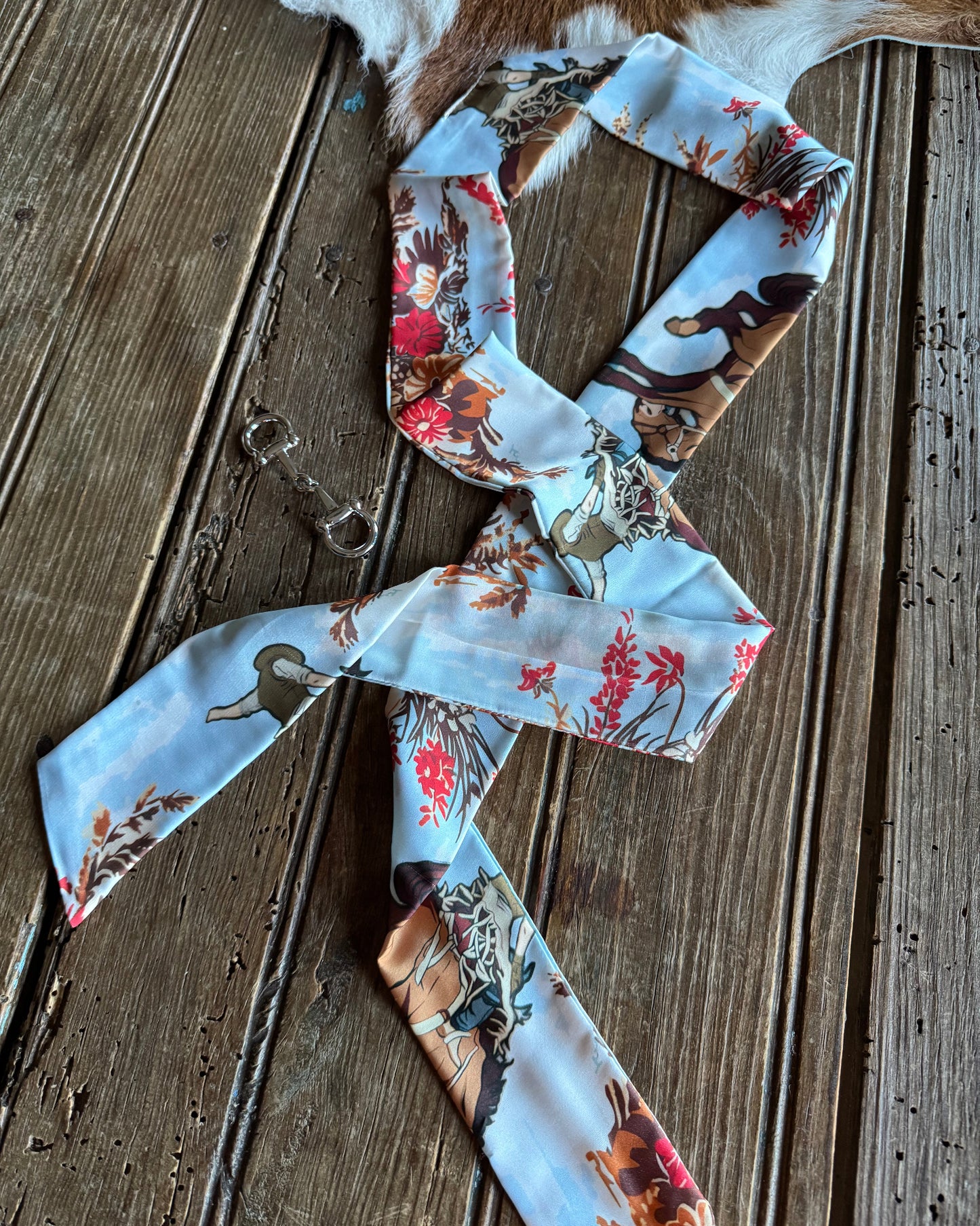 ribbon scarf with nature-themed print on a wooden surface