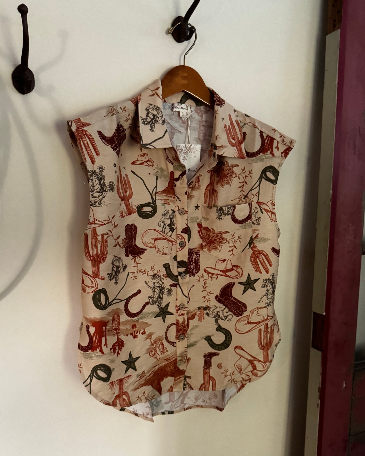Sleeveless blouse hanging on a wall by a red door