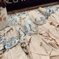 Beige napkins with silver cowboy boot and hat decorations on a marble surface.