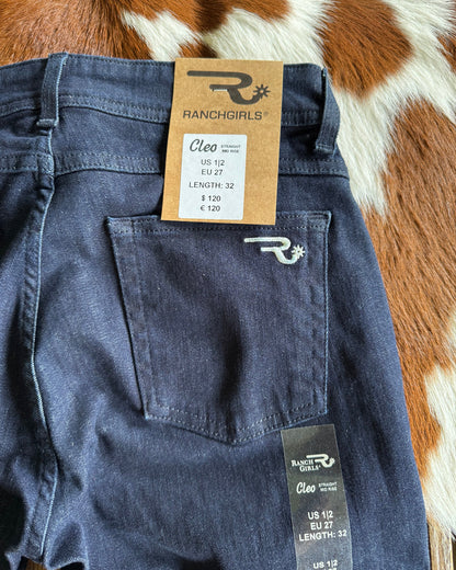 Blue jeans with brand tags on a cowhide rug