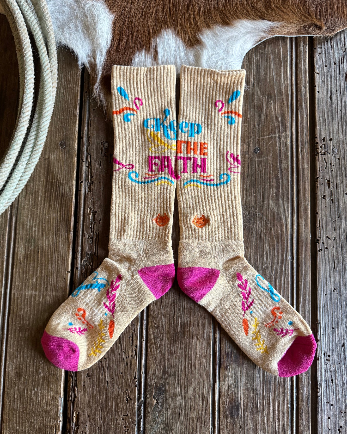 Colorful socks with text and designs on a wooden surface