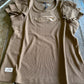 Brown t-shirt with a logo on a wooden surface