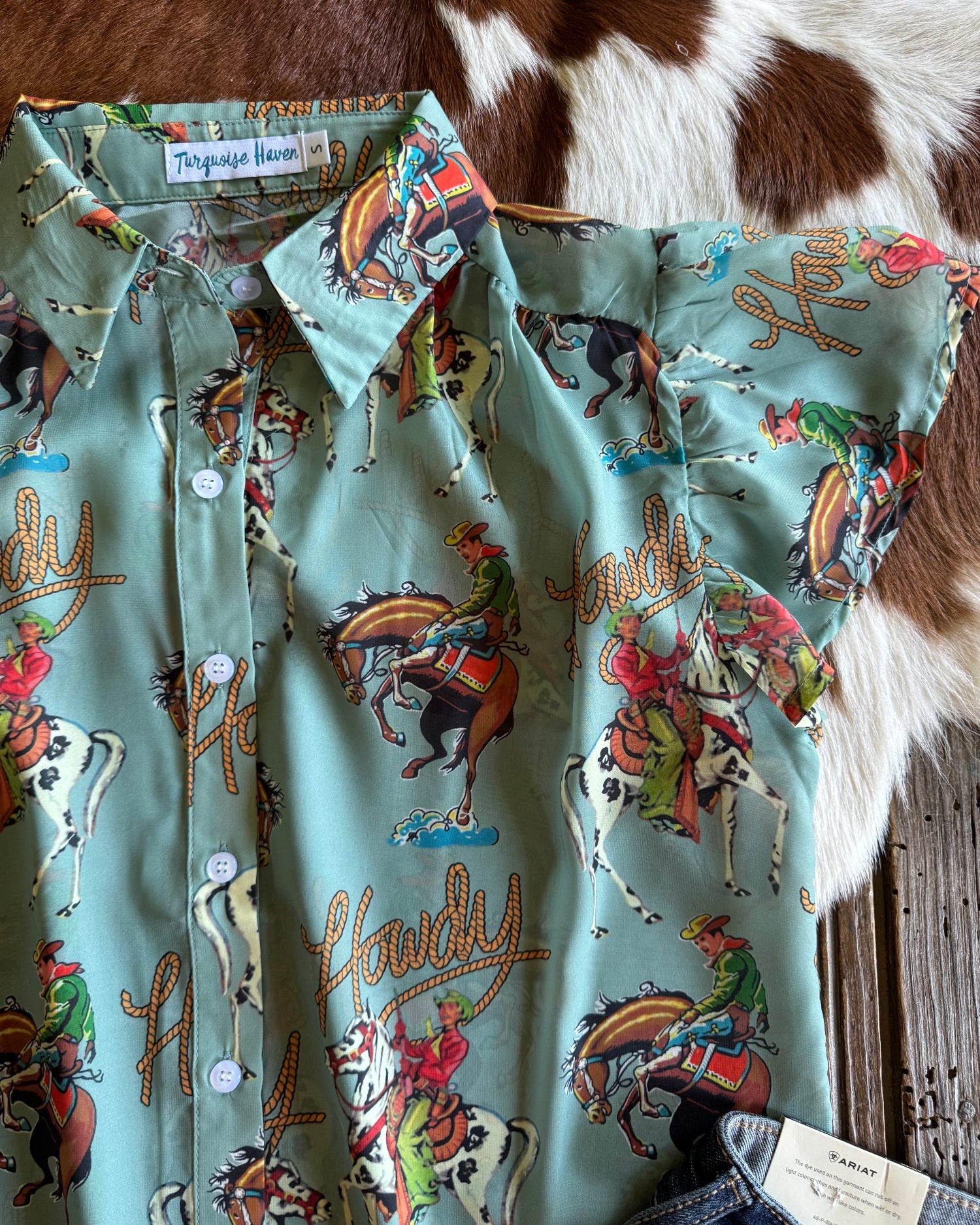 Blouse with cowboy and horse pattern on a cowhide surface