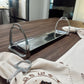 Metal equestrian stirrup napkin holder on a wooden table with embroidered napkins.