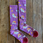 Lucky Unicorns Performance Socks in purple on rustic wood background 