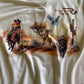 White t-shirt with desert-themed graphic design featuring a horse, cactus, and birds.