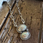 Necklace with two circular pendants on a wooden surface