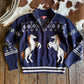 Navy blue sweater with horse designs on a wooden surface with cowhide rug