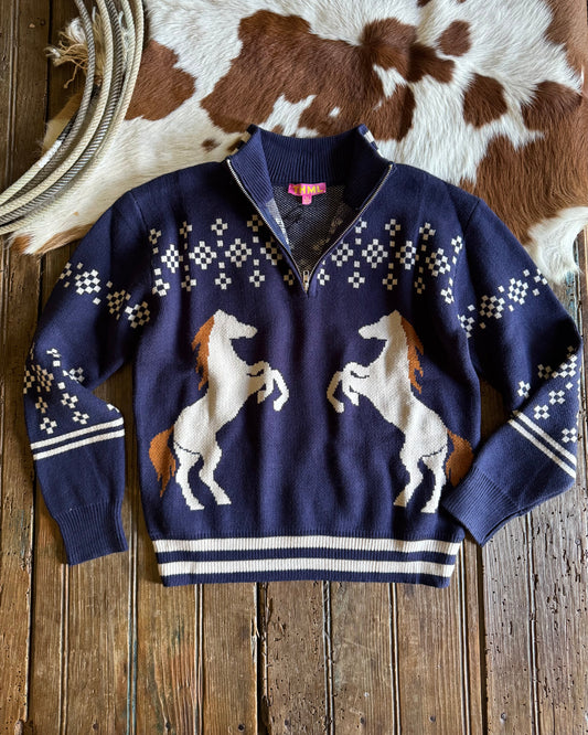 Navy blue sweater with horse designs on a wooden surface with cowhide rug