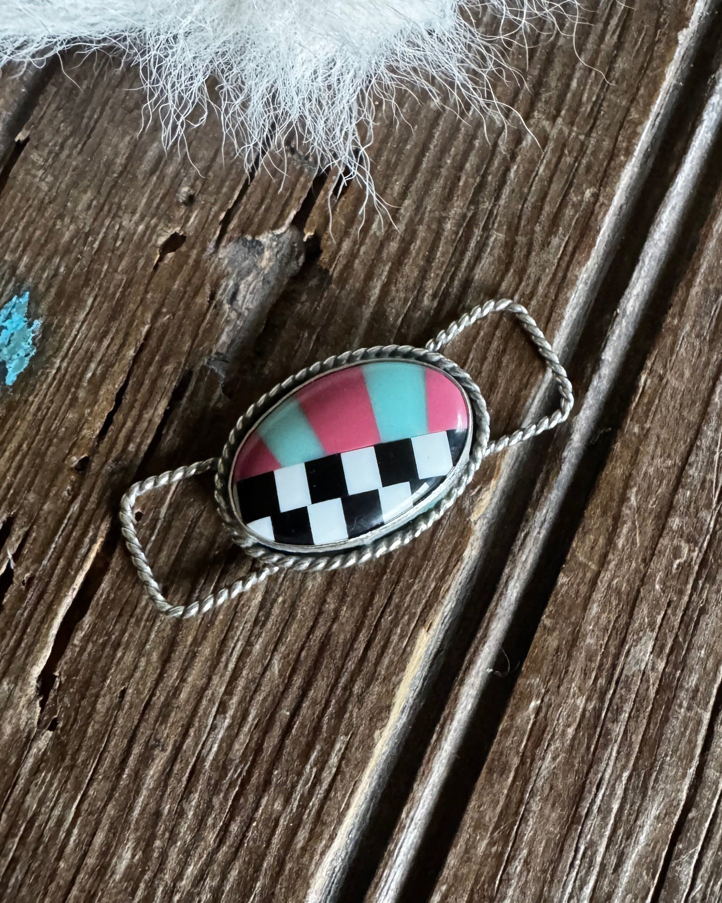 Decorative twilly slide with checkered design on a wooden surface