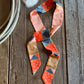 Patchwork ribbon scarf on a rustic wooden background with a rope