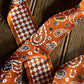 Orange and white patterned ribbon on a wooden surface