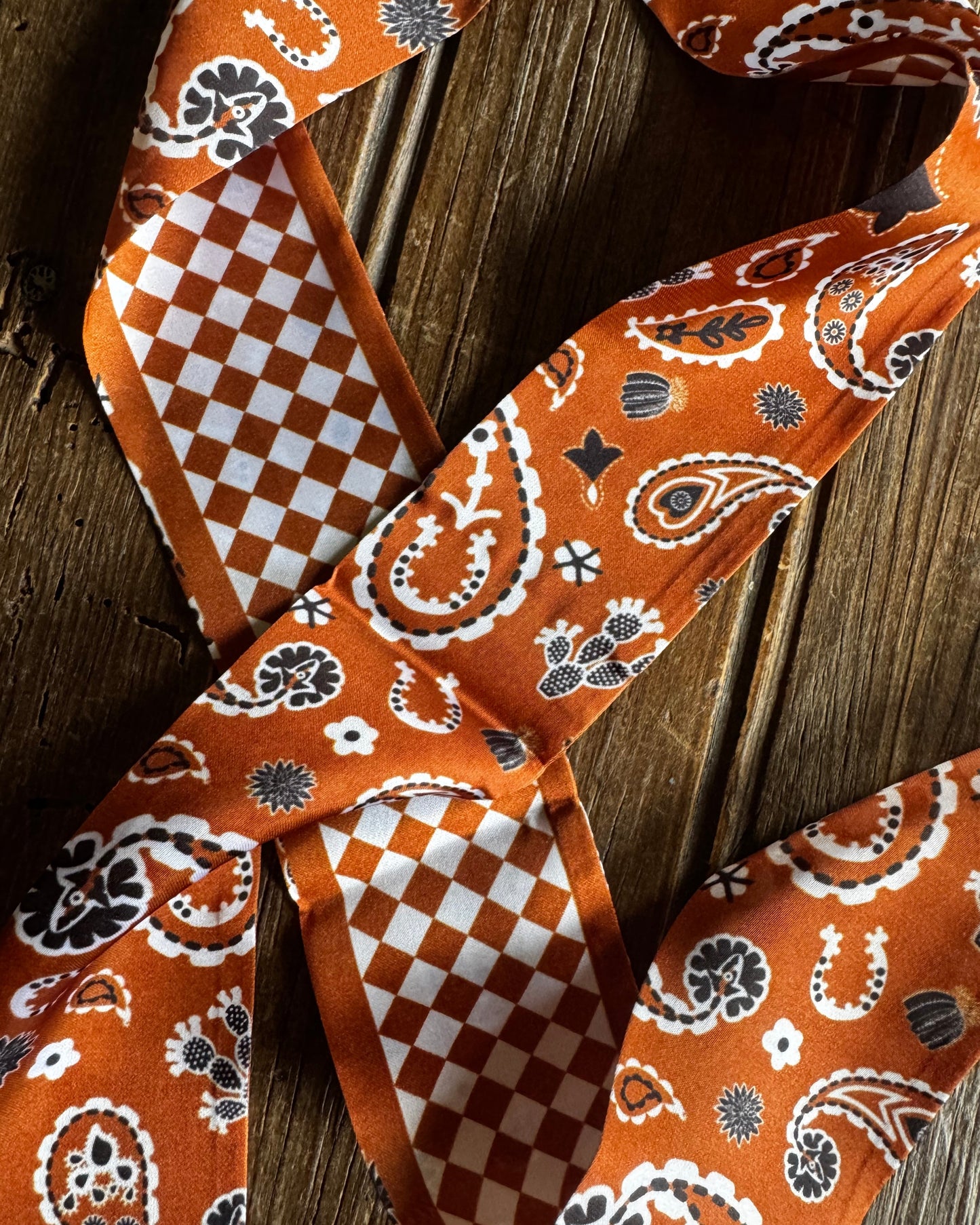 Orange and white patterned ribbon on a wooden surface