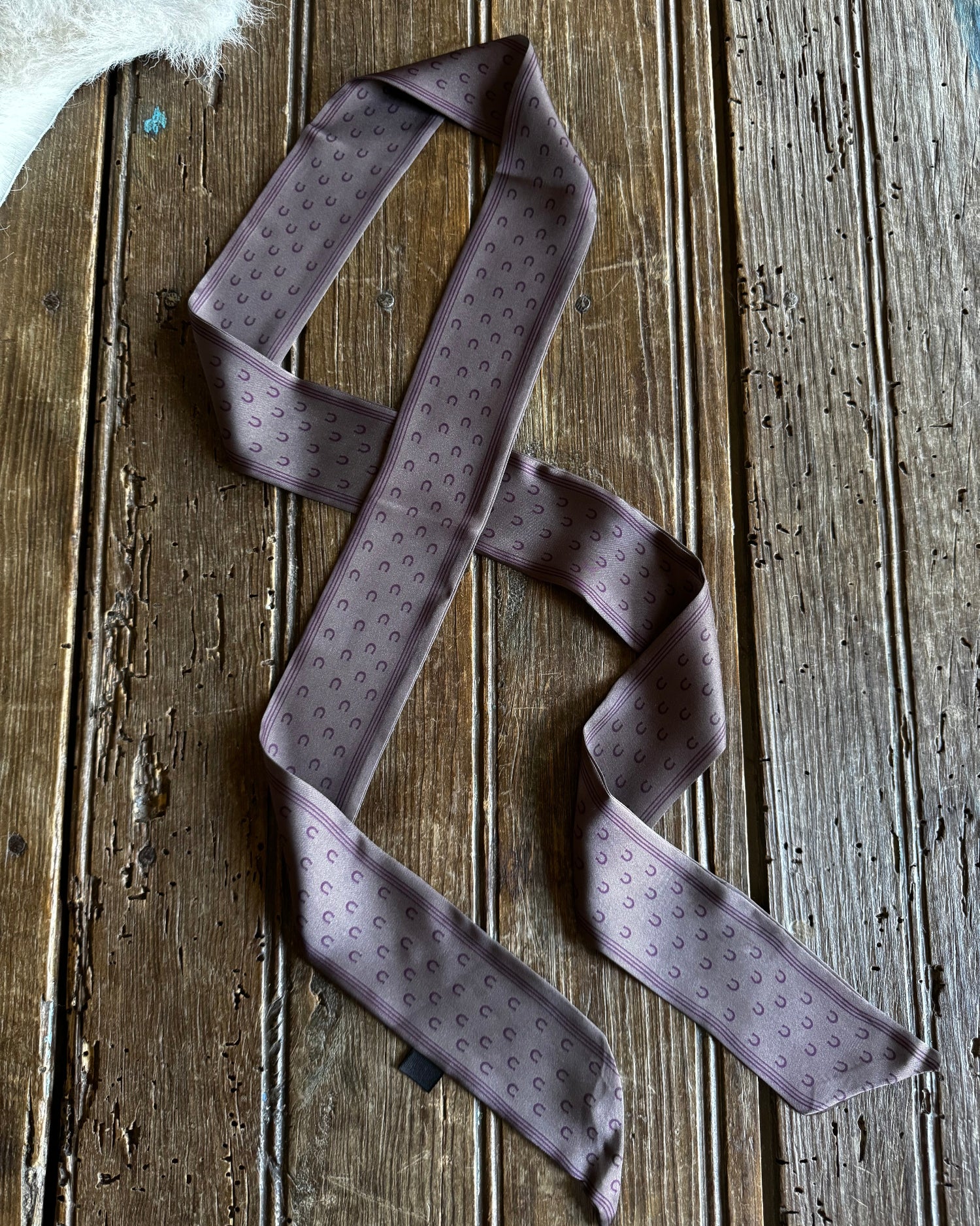 Purple patterned tie on a wooden surface