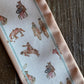 Close up of ribbon scarf with cowboys on rustic wooden background