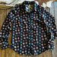 Black patterned fabric on a wooden surface with cowhide rug and rope