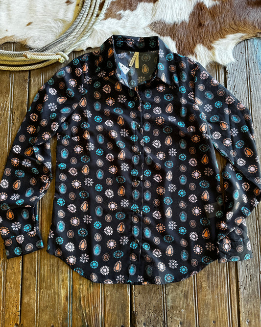 Black patterned fabric on a wooden surface with cowhide rug and rope