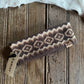 Patterned headband on a wooden surface with a cowhide rug in the background